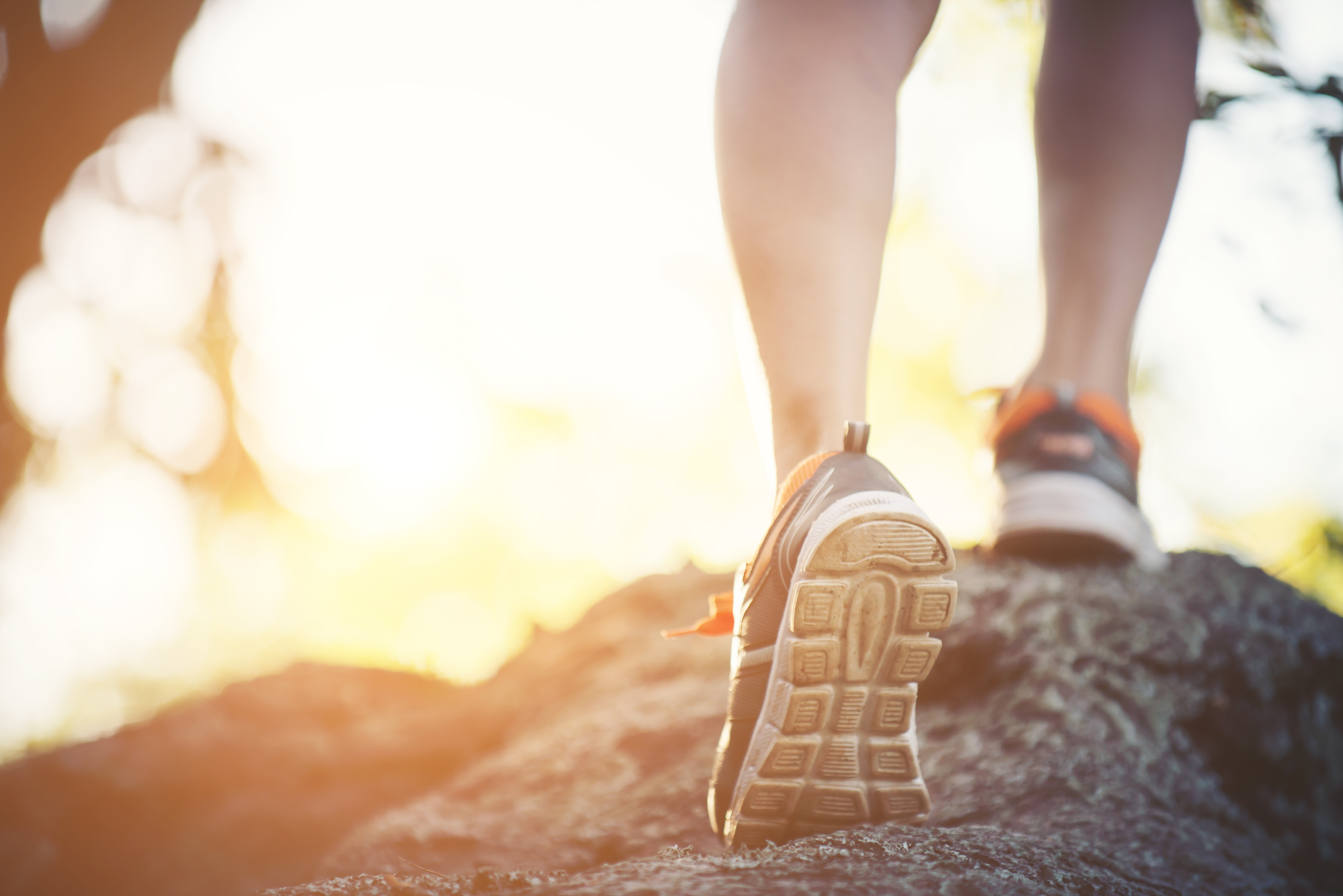 young runner woman legs close-up during running across the rock, Healthy lifestyle. Sport fitness woman.